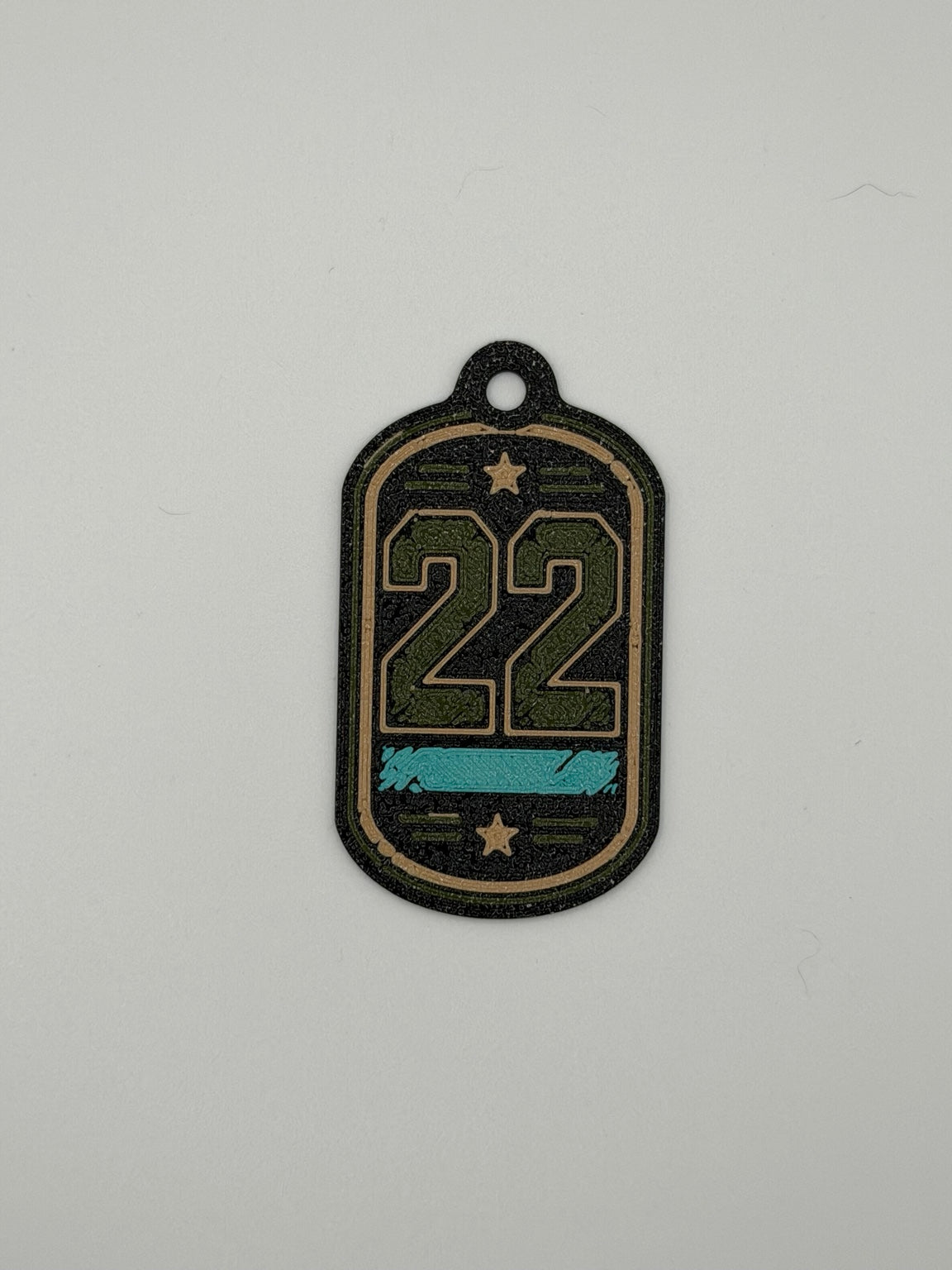 3D printed 22 veteran support dog tag keychain in black, green, tan, and teal